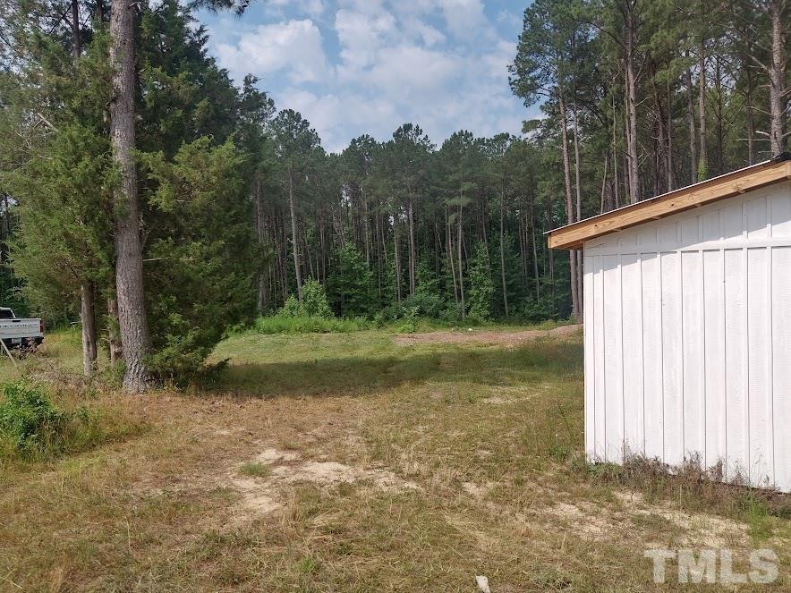5209 Pulley Town Road Zebulon, NC 27597 - Photo 2 of 9 a view of a backyard with large trees
