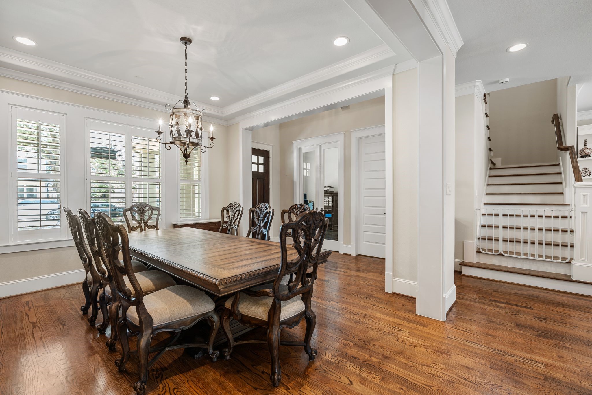 1217 Chippendale Road Houston, TX 77018 - Photo 7 of 42 Designed for entertaining, the formal dining room features abundant natural light, plantation shutters, hardwood flooring, crown molding, & a tray ceiling create a polished yet inviting atmosphere for dinner parties & special occasions. French door to the left lead to the study. Enjoy convenient access to the serving bar & kitchen towards the right.