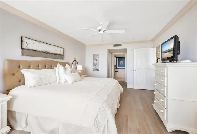 a spacious bedroom with a bed and a flat screen tv