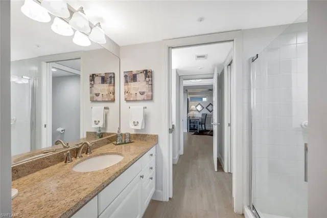 a en suite bathroom with a granite countertop sink and a mirror