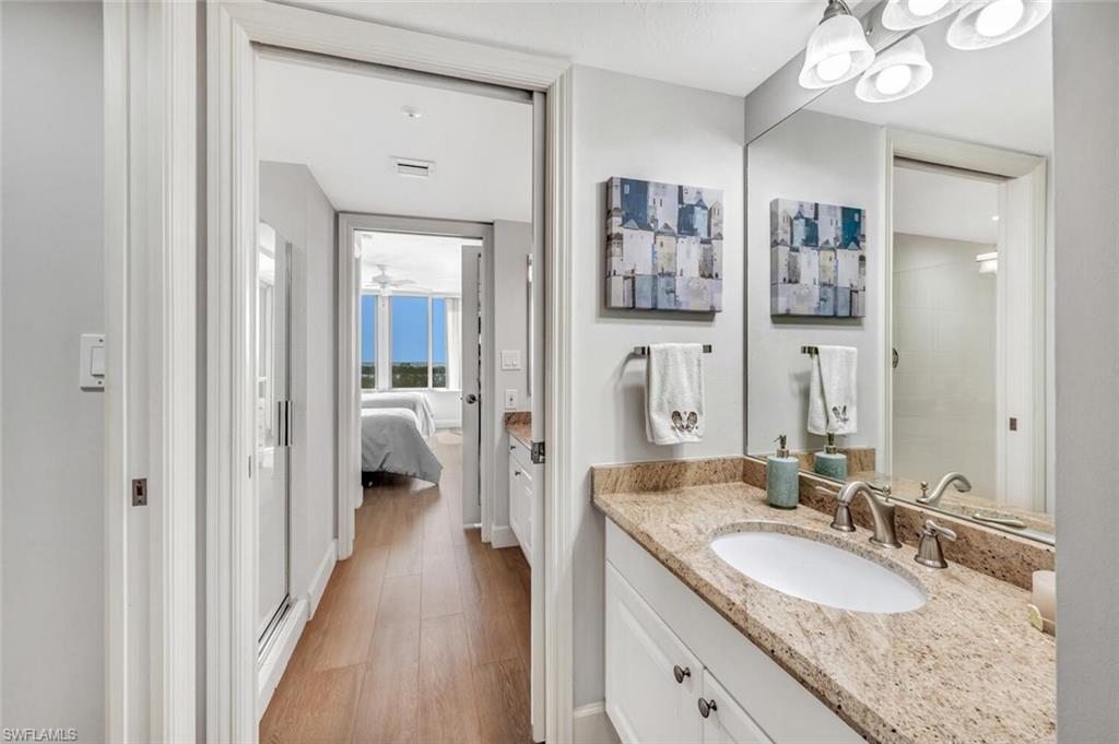 6849 Grenadier Boulevard, Unit 503 Naples, FL 34108 - Photo 27 of 50 a en suite bathroom with a granite countertop double vanity sink and a mirror