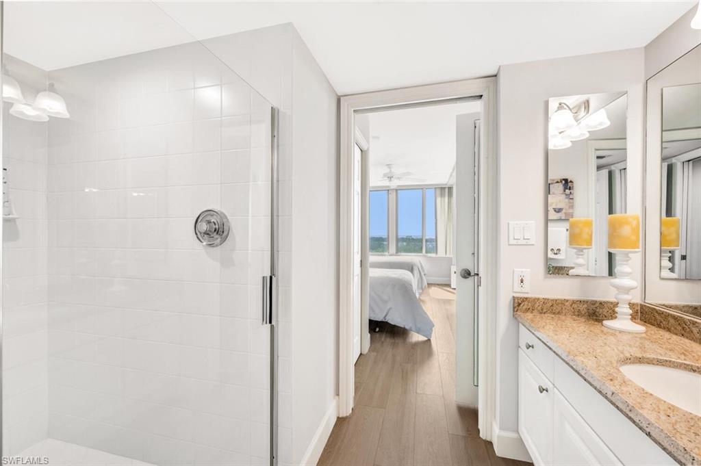 6849 Grenadier Boulevard, Unit 503 Naples, FL 34108 - Photo 28 of 50 a bathroom with a granite countertop sink and a mirror