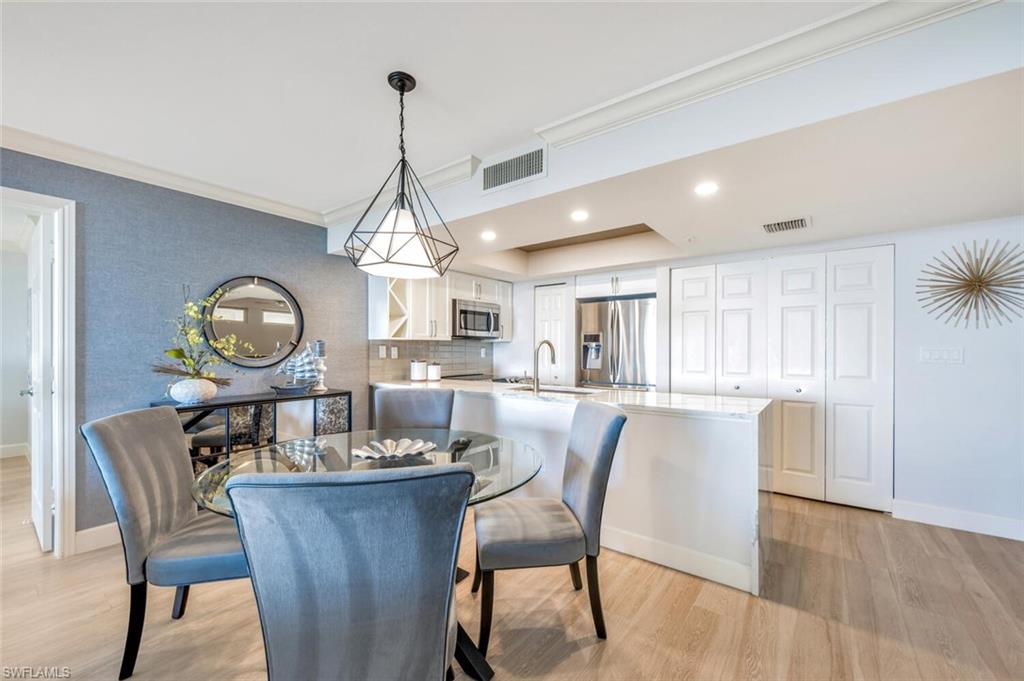 6849 Grenadier Boulevard, Unit 503 Naples, FL 34108 - Photo 10 of 50 a dining room with furniture a chandelier and wooden floor