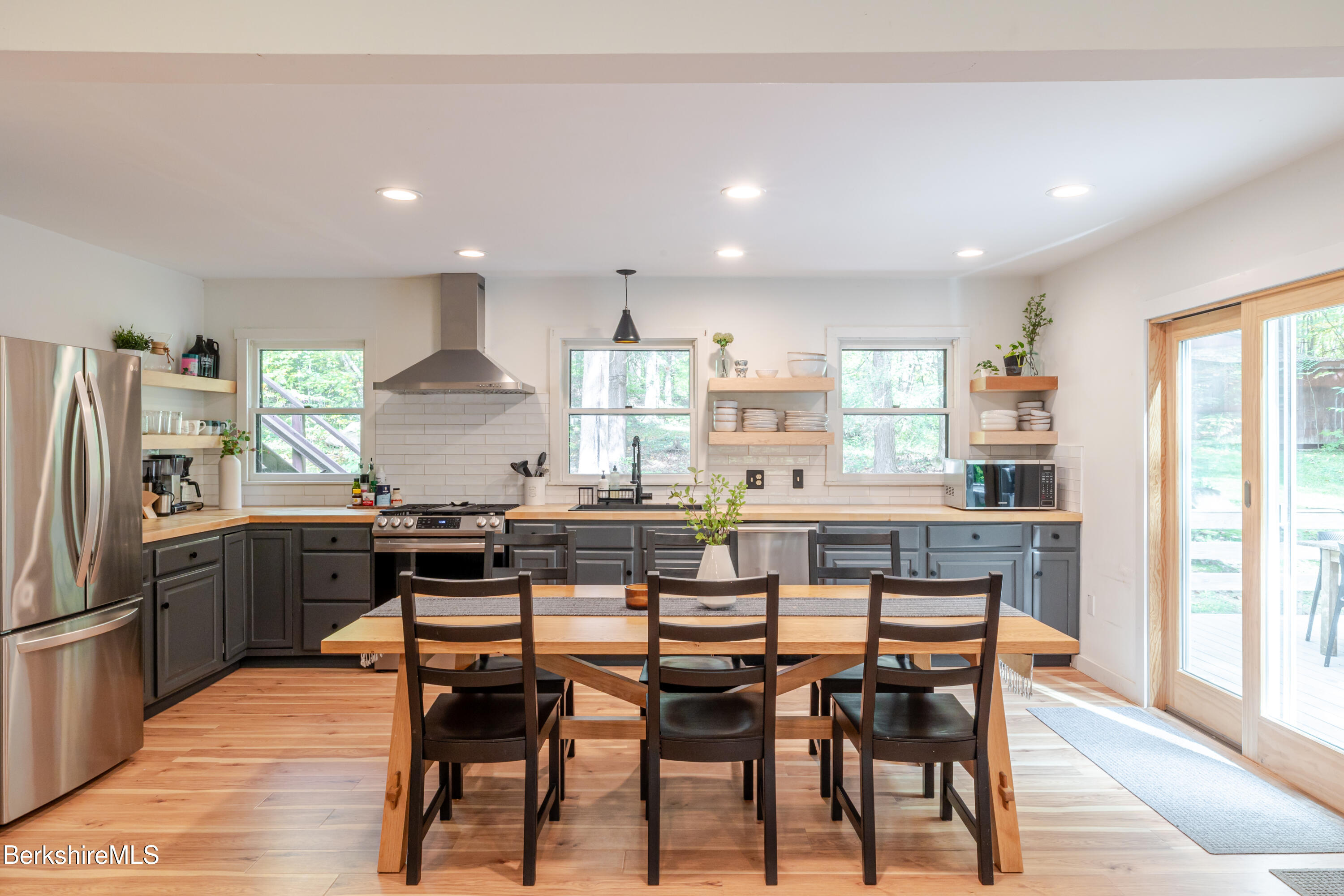 176 Division Street Great Barrington, MA 01230 - Photo 11 of 40 a kitchen with stainless steel appliances kitchen island granite countertop a dining table chairs and granite counter tops
