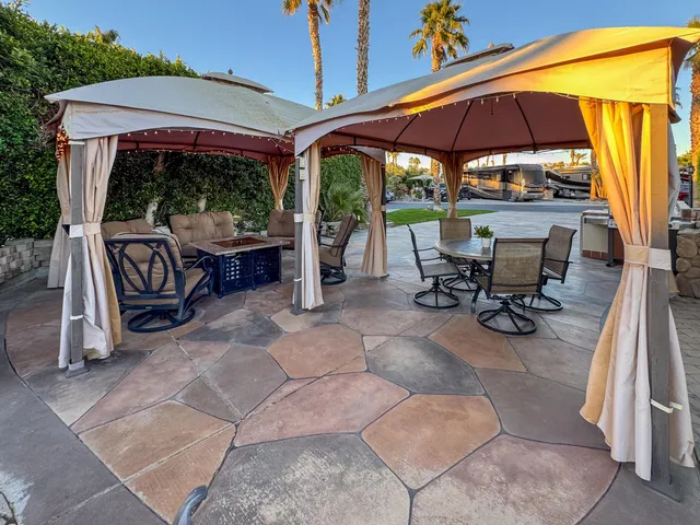 a view of a patio with a table and chairs under an umbrella