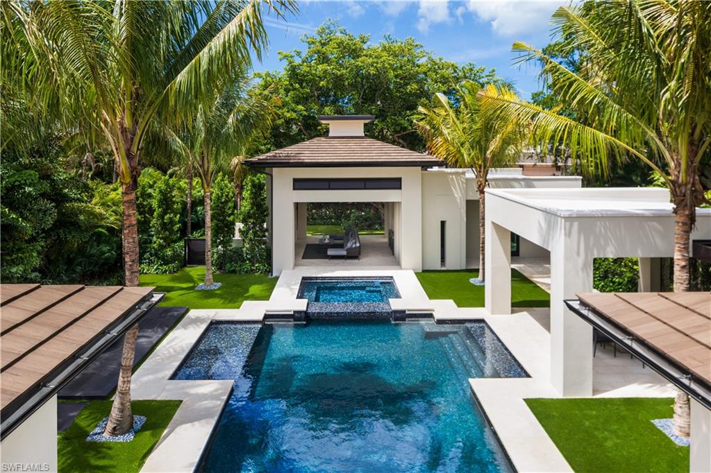 477 3rd Street North Naples, FL 34102 - Photo 4 of 33 swimming pool view with a seating space and a garden