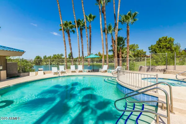 a view of a swimming pool with a patio and a yard