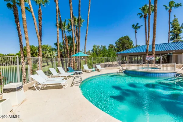 a view of swimming pool with chairs and table in patio
