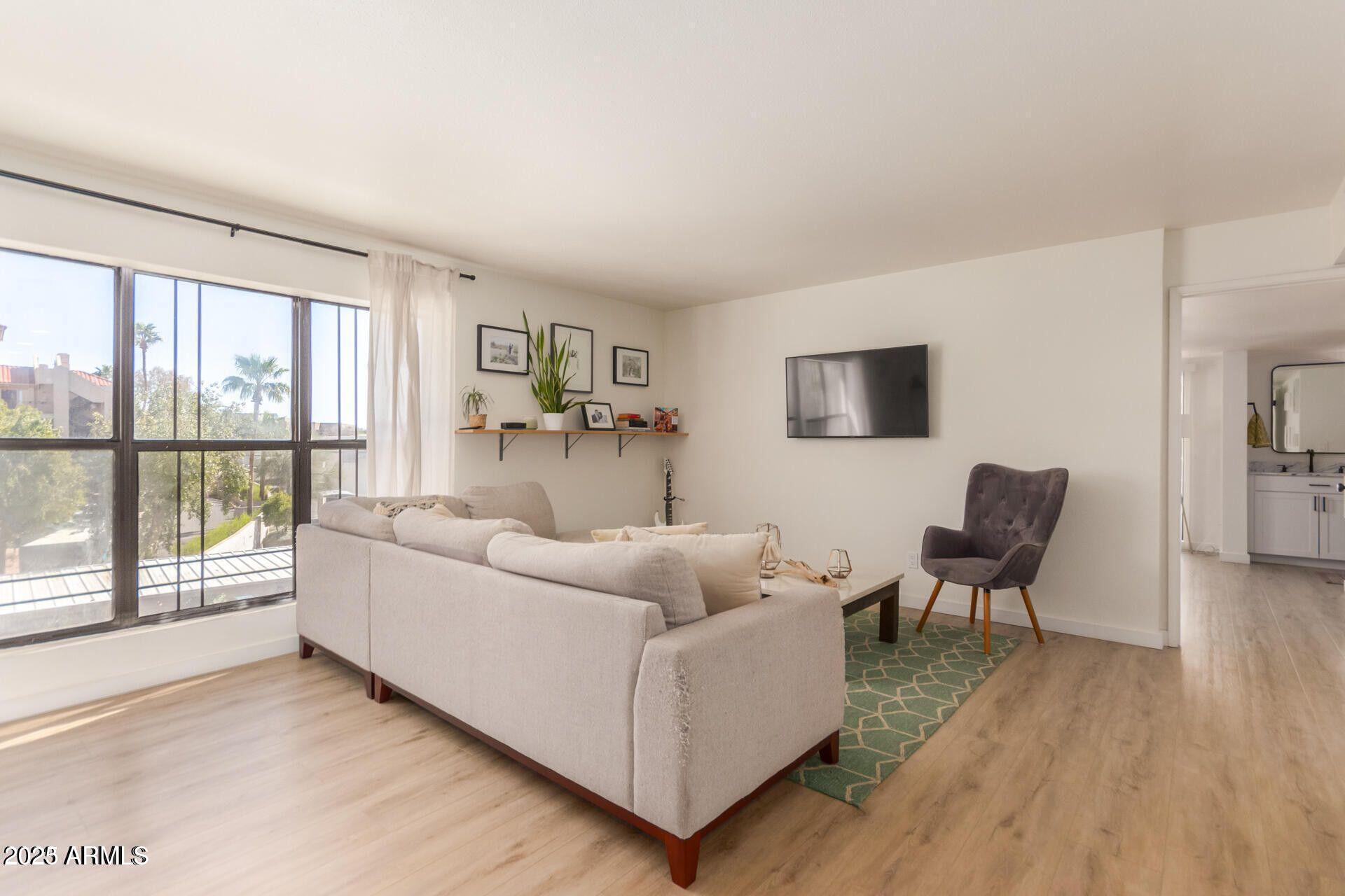 5122 North 31st Way, Unit 238 Phoenix, AZ 85016 - Photo 2 of 21 a living room with furniture and a flat screen tv