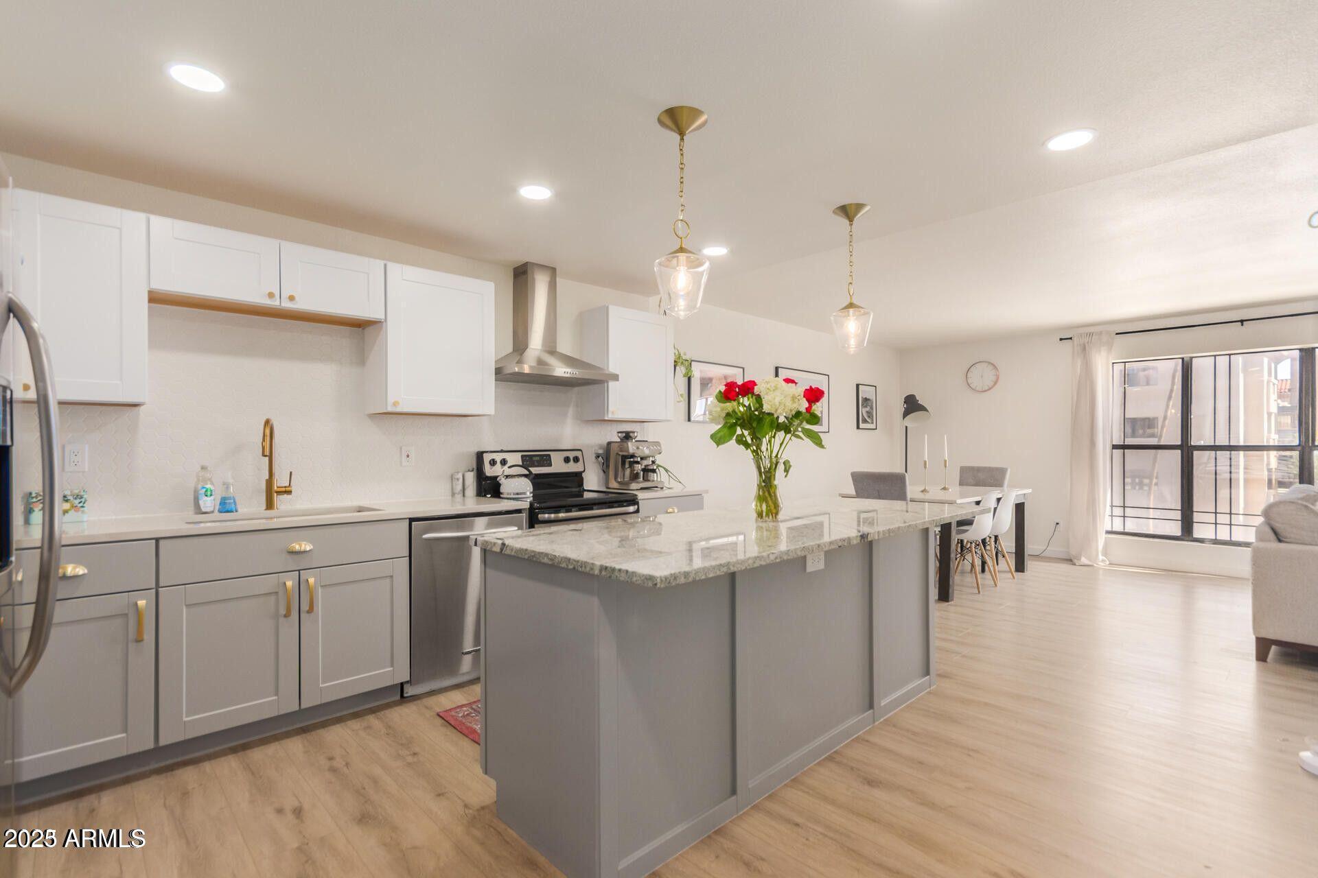 5122 North 31st Way, Unit 238 Phoenix, AZ 85016 - Photo 5 of 21 a kitchen that has a lot of cabinets a sink in it and wooden floors