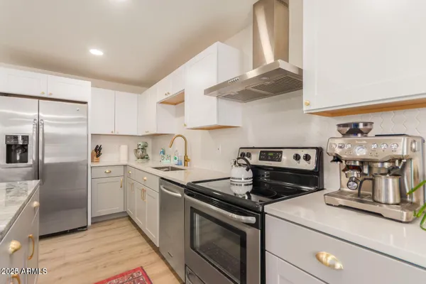 a kitchen with stainless steel appliances granite countertop a sink stove and refrigerator