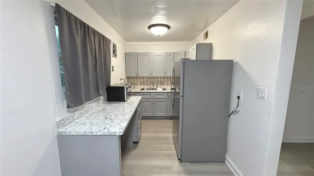 a kitchen with granite countertop a refrigerator and a sink