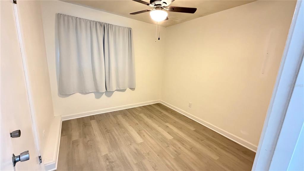 6310 Lake Underhill Road, Unit A Orlando, FL 32807 - Photo 7 of 12 an empty room with a window and a fan