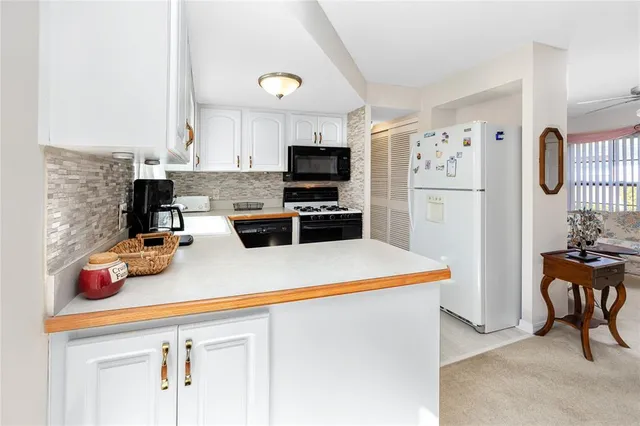 a kitchen with a refrigerator a stove and a dining table with wooden floor