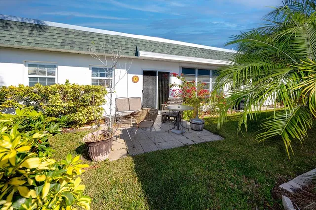 a view of a house with chair and table in the patio