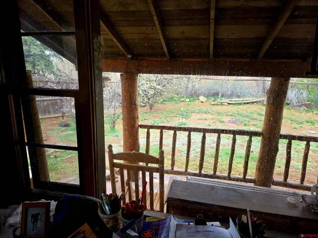 a view of a hallway with wooden floor and a bathroom