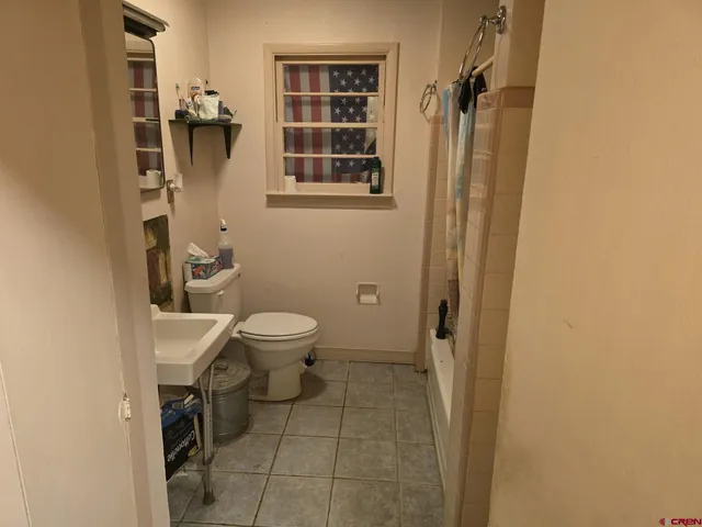 a picture of a living room with furniture and a mirror