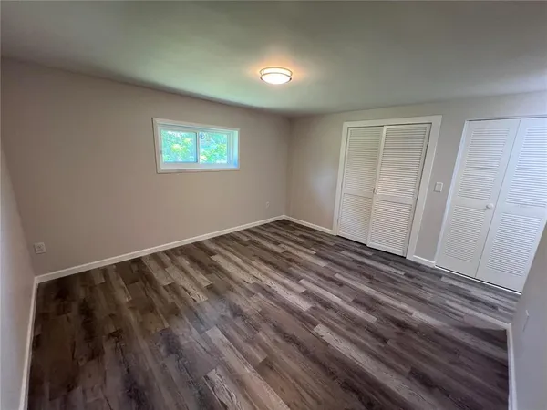 a view of a small space with wooden floor and a window