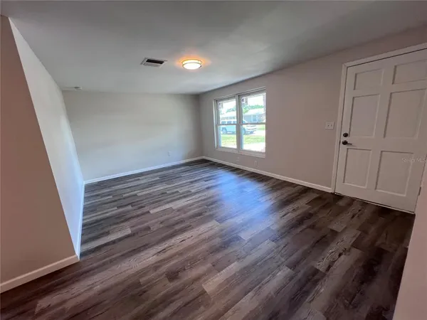 a view of room with window and wooden floor