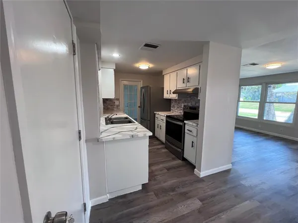 a kitchen with stainless steel appliances granite countertop a stove a sink and a refrigerator