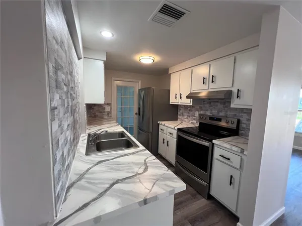 a kitchen with a stove sink and refrigerator