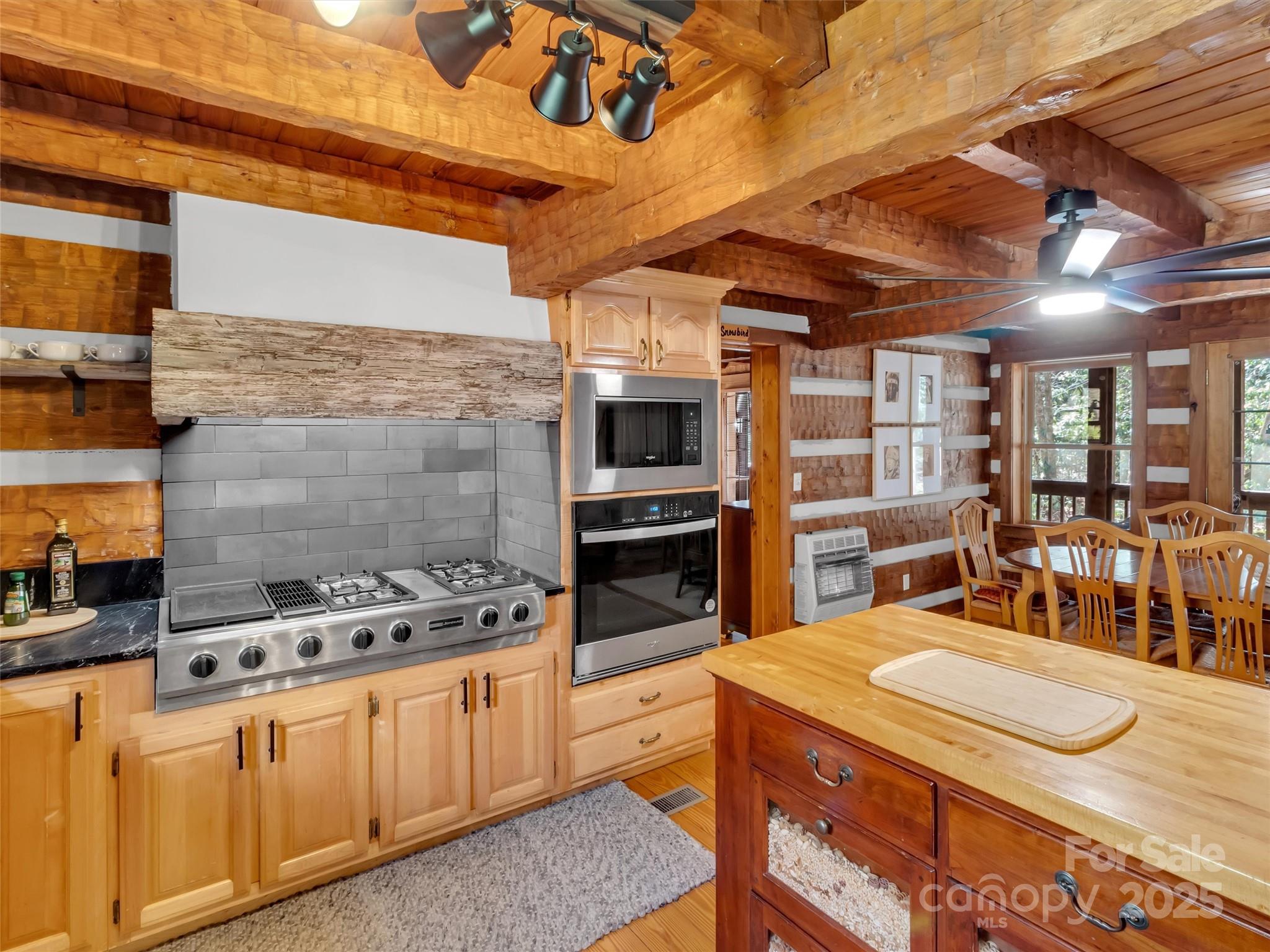 7810 Little Snowbird Road Robbinsville, NC 28771 - Photo 13 of 48 a kitchen with stainless steel appliances kitchen island granite countertop a stove a sink and a microwave