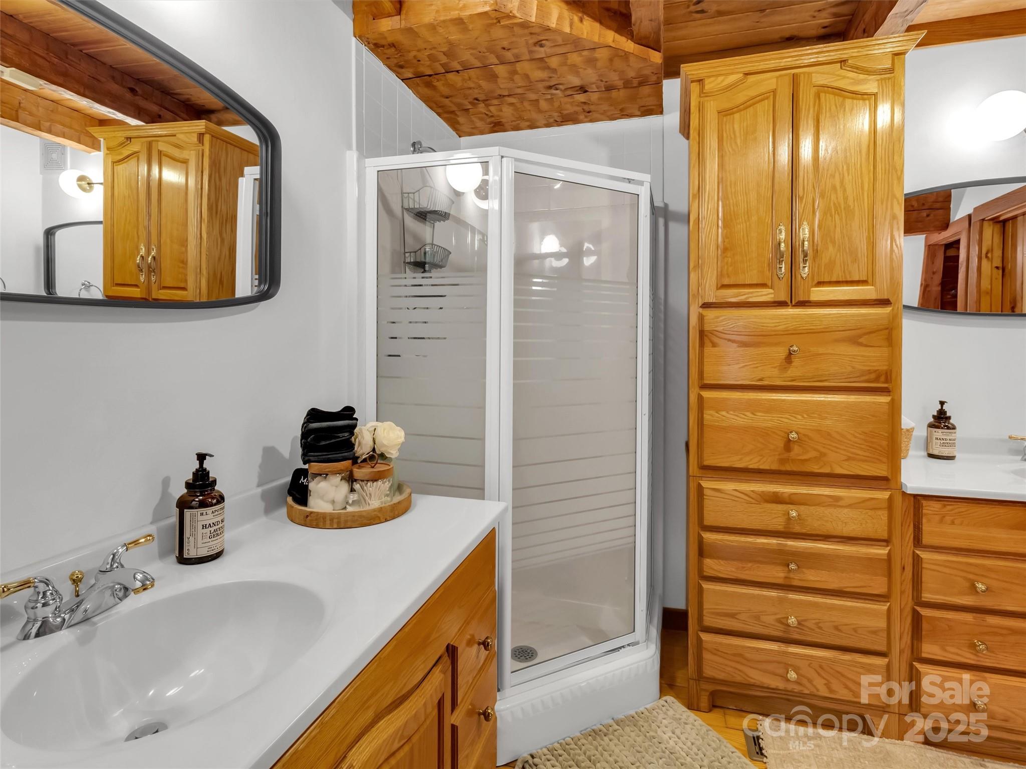 7810 Little Snowbird Road Robbinsville, NC 28771 - Photo 22 of 48 a bathroom with a sink a mirror and shower in a bathroom