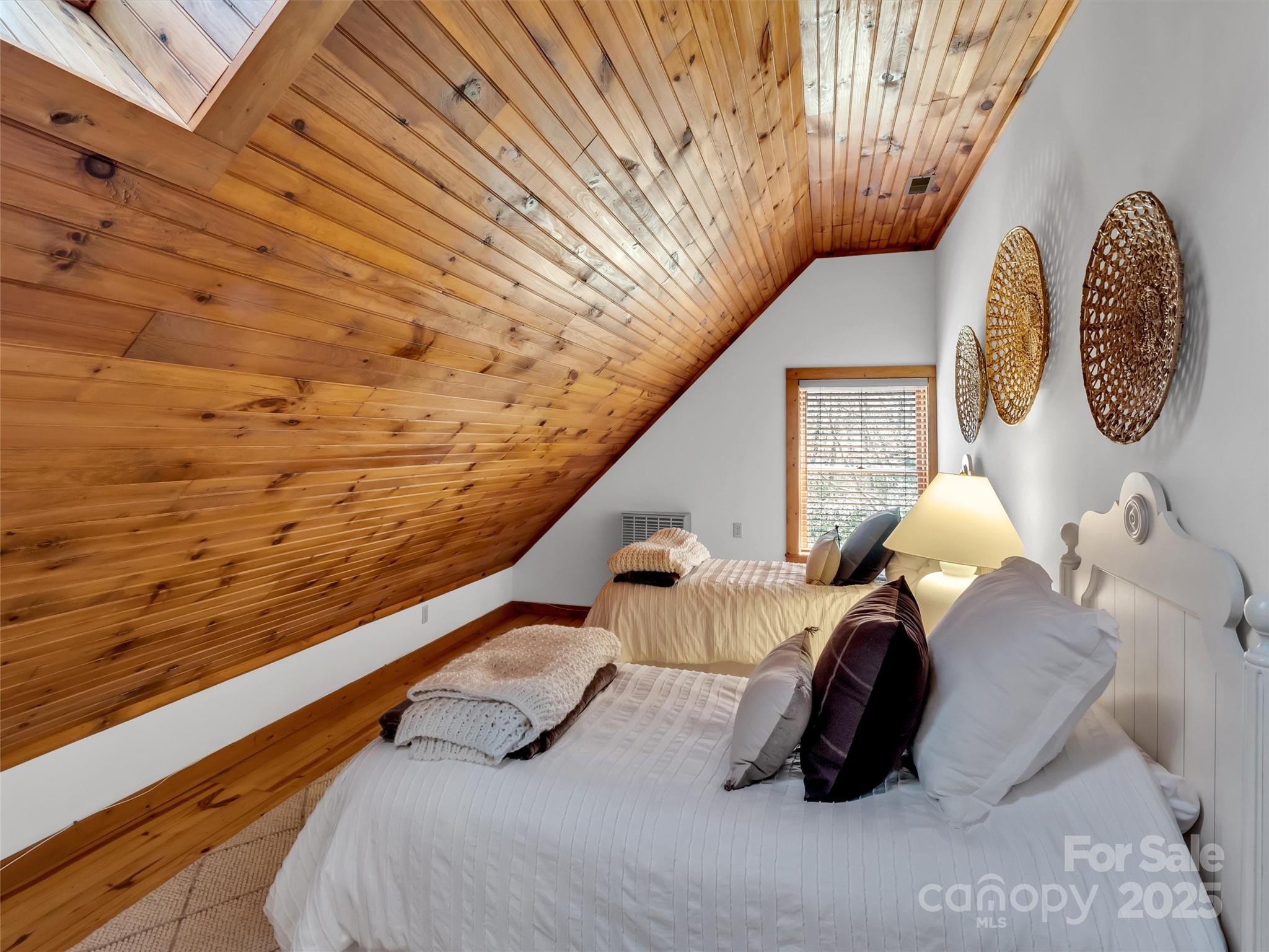 7810 Little Snowbird Road Robbinsville, NC 28771 - Photo 36 of 48 a bedroom with a bed and a chandelier