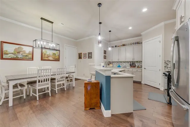 a kitchen with a dining table chairs stainless steel appliances and cabinets
