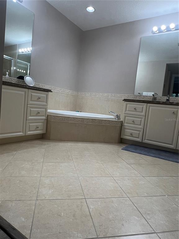 37 Harbour Isle Drive East, Unit 206 Fort Pierce, FL 34949 - Photo 17 of 37 a bathroom with a bathtub sink and mirror
