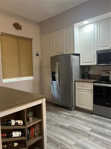 a kitchen with stainless steel appliances a refrigerator and a stove top oven