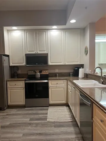 a kitchen with stainless steel appliances granite countertop a stove a sink and a microwave
