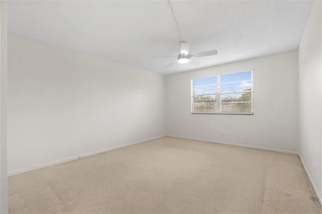 an empty room with a fan and a ceiling fan