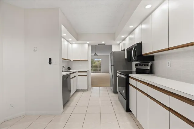 a kitchen with granite countertop a stove a sink and a microwave