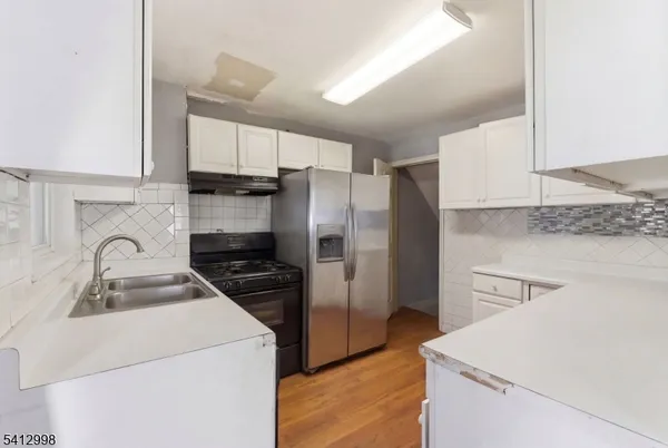 a kitchen with a refrigerator sink and cabinets