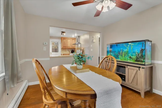 a dining room with furniture a large window and wooden floor