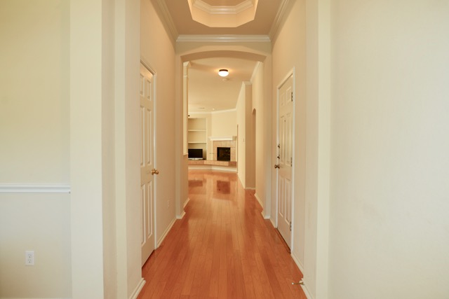 138 Chestnut Court Georgetown, TX 78633 - Photo 4 of 25 A graceful entrance hallway opens to a living space, showcasing polished wood flooring and thoughtful architectural details.