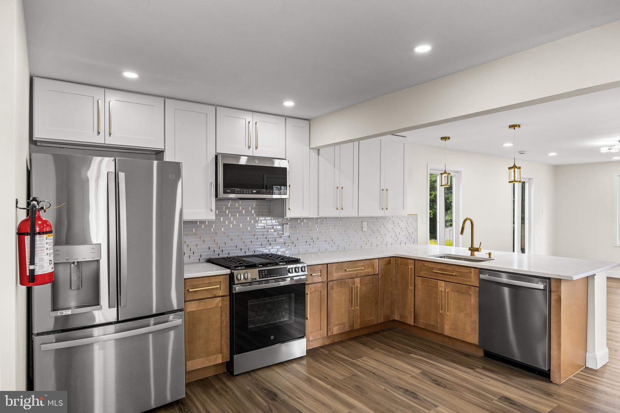 937 Clements Bridge Road Barrington, NJ 08007 - Photo 11 of 34 a kitchen with stainless steel appliances and wooden cabinets