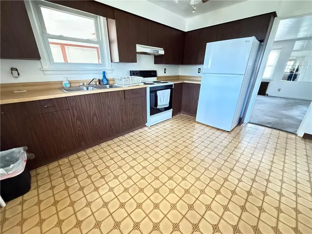 a kitchen with a sink a refrigerator and cabinets