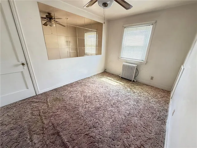 an empty room with a rug and a window