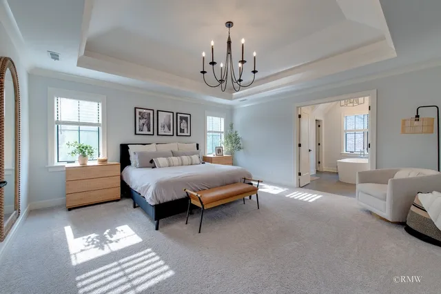 a spacious bedroom with a bed window and a chandelier