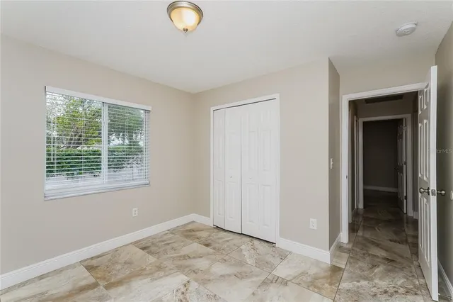 a view of an empty room with window and hallway