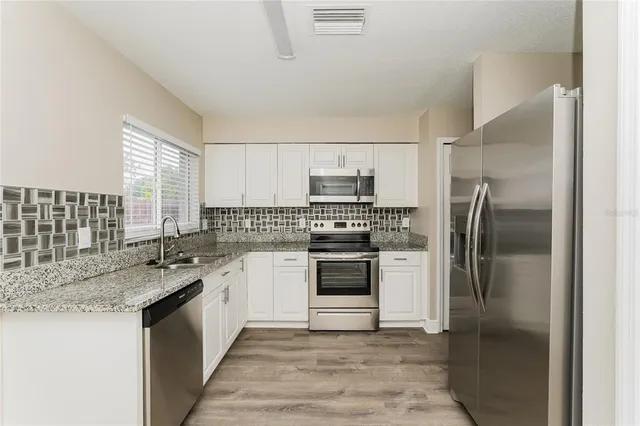 a kitchen with a sink stove and refrigerator