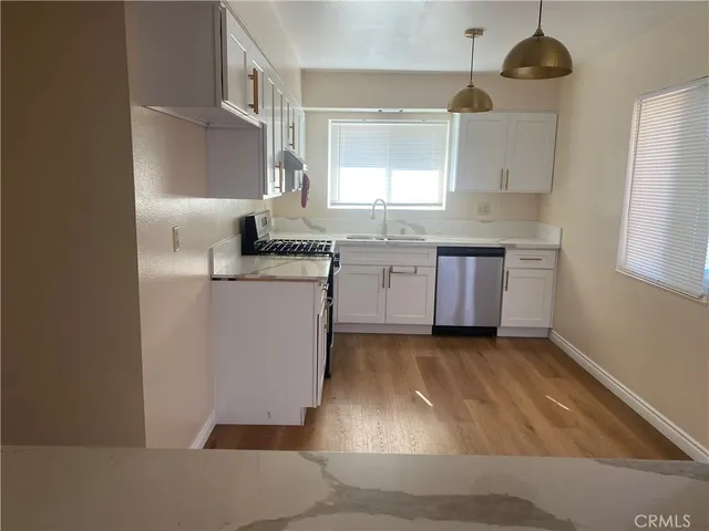 a kitchen with a sink stainless steel appliances and cabinets