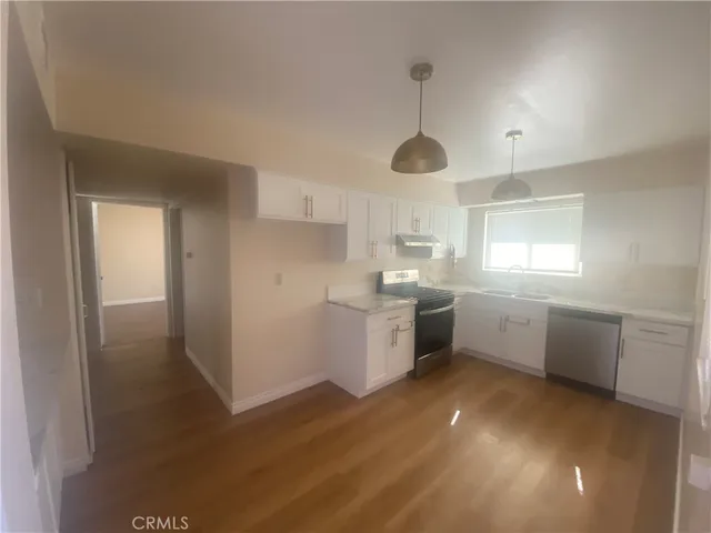 a kitchen with a white cabinets and window