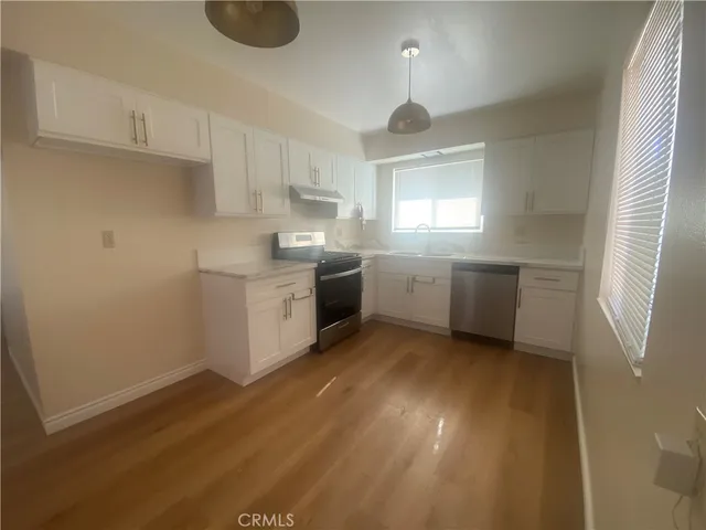 a kitchen with stainless steel appliances granite countertop a sink a stove a refrigerator and cabinets