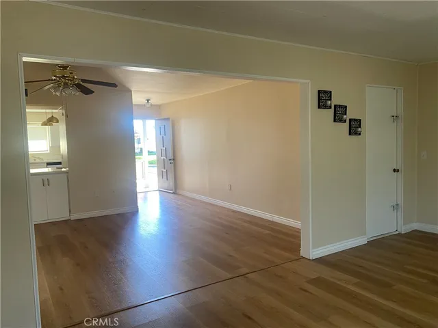a view of a hallway with wooden floor and a cabinet