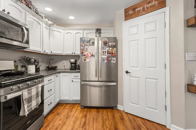 a kitchen with stainless steel appliances granite countertop a refrigerator and a stove top oven