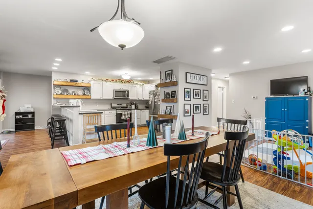 a room with stainless steel appliances lots of furniture and a dining table