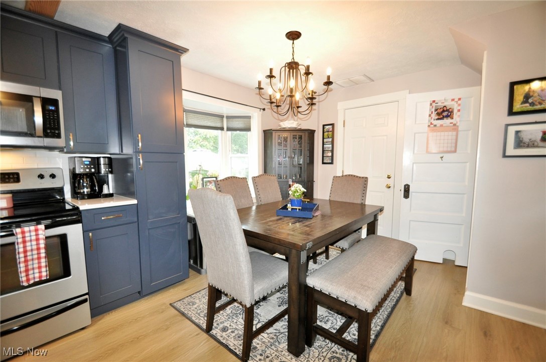 467 Cahoon Road Bay Village, OH 44140 - Photo 11 of 41 Dining area with light wood-style floors and a chandelier